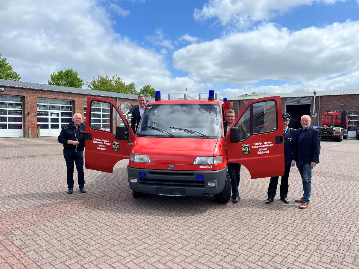 a group of people standing next to a red truck