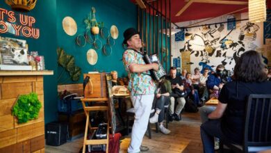 a man playing an accordion in a room with people watching