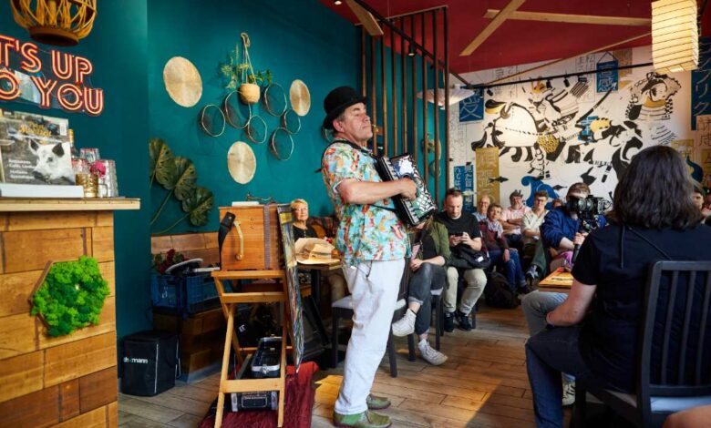 a man playing an accordion in a room with people watching