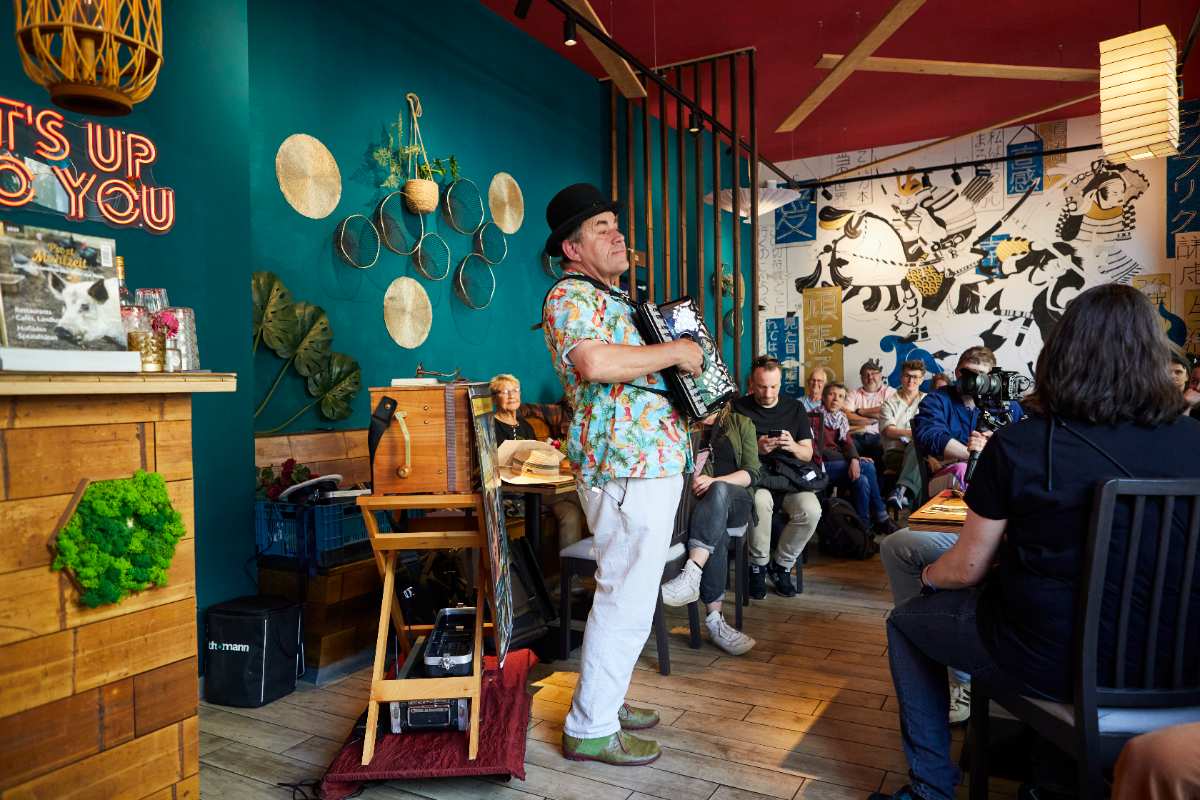 a man playing an accordion in a room with people watching