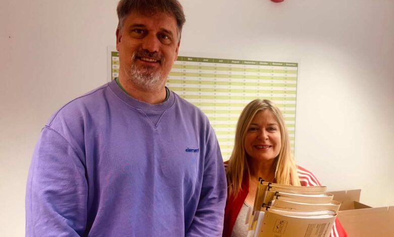 a man and woman holding files