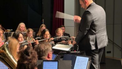 a man in a suit and a band playing instruments