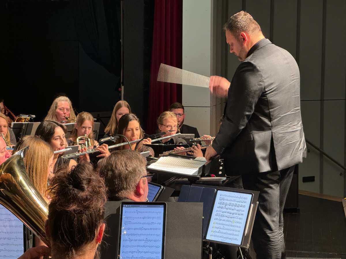 a man in a suit and a band playing instruments