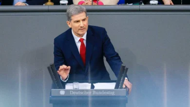 a man in a suit sitting at a podium