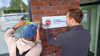 a man holding a yellow ruler and pointing at a sign
