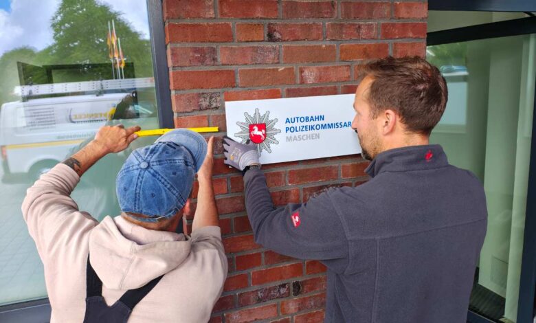 a man holding a yellow ruler and pointing at a sign