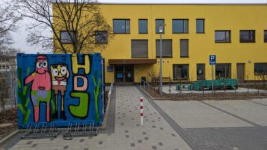 a yellow building with a blue wall with cartoon characters on it