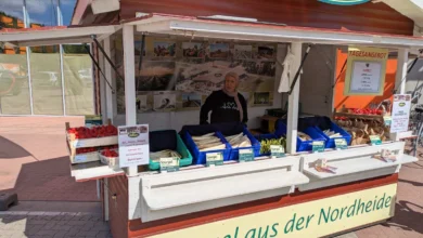 a man standing in front of a food stand