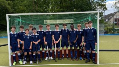 a group of boys in blue uniforms standing in front of a goal