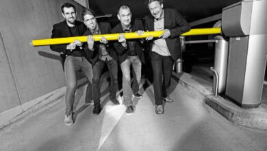 a group of men holding a yellow pole