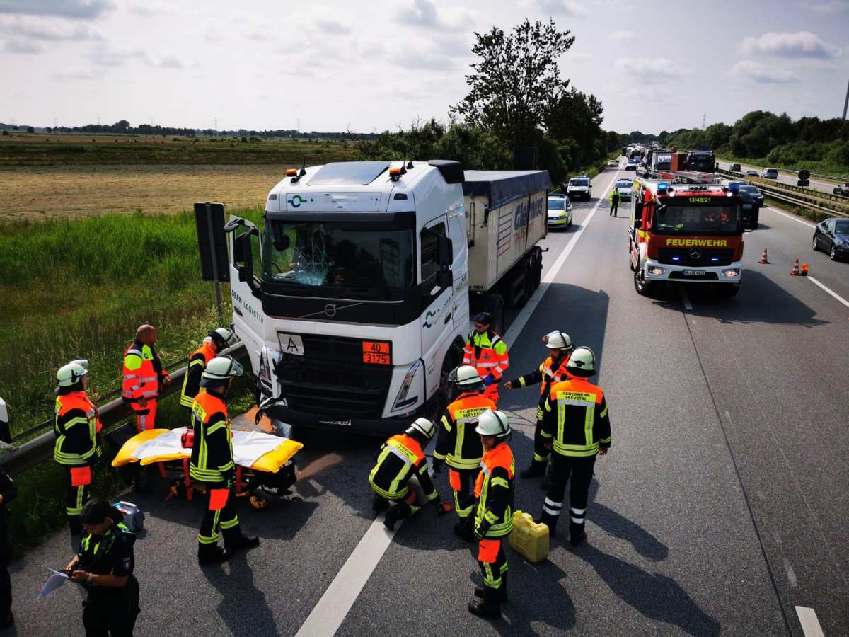 a group of people in orange jackets and white vests standing next to a truck