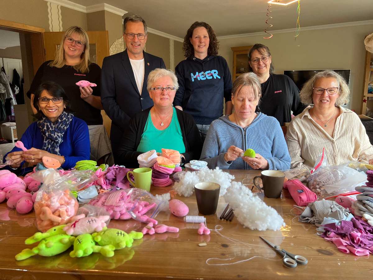 a group of people sitting around a table with objects on it