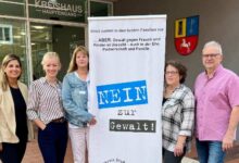 a group of women standing next to a sign