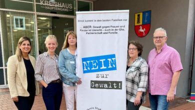 a group of women standing next to a sign