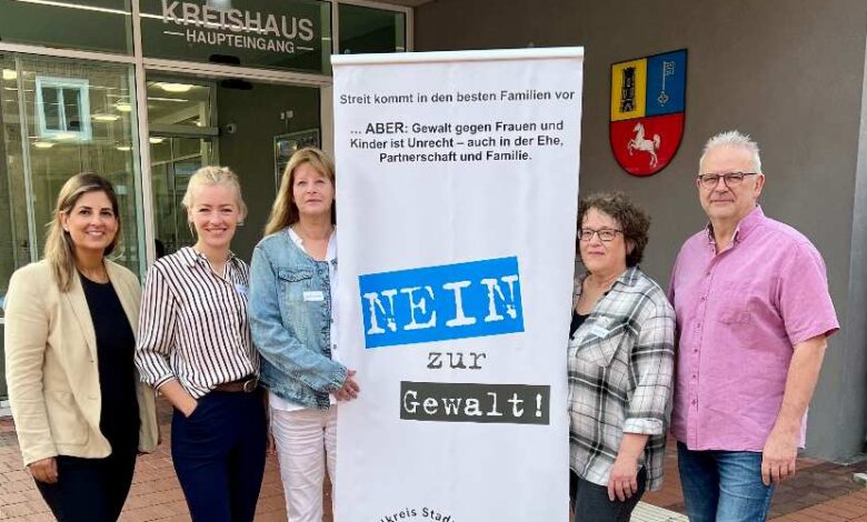 a group of women standing next to a sign
