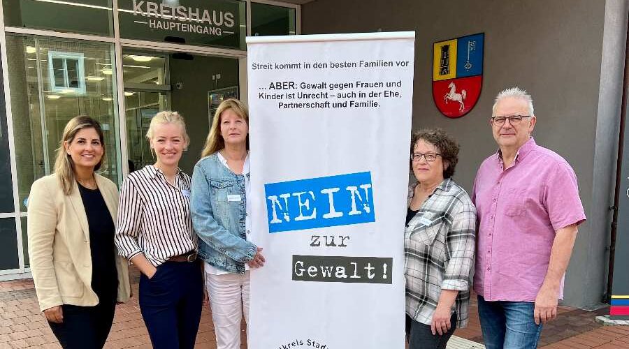 a group of women standing next to a sign