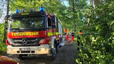 a fire truck parked on a dirt road with people in uniform