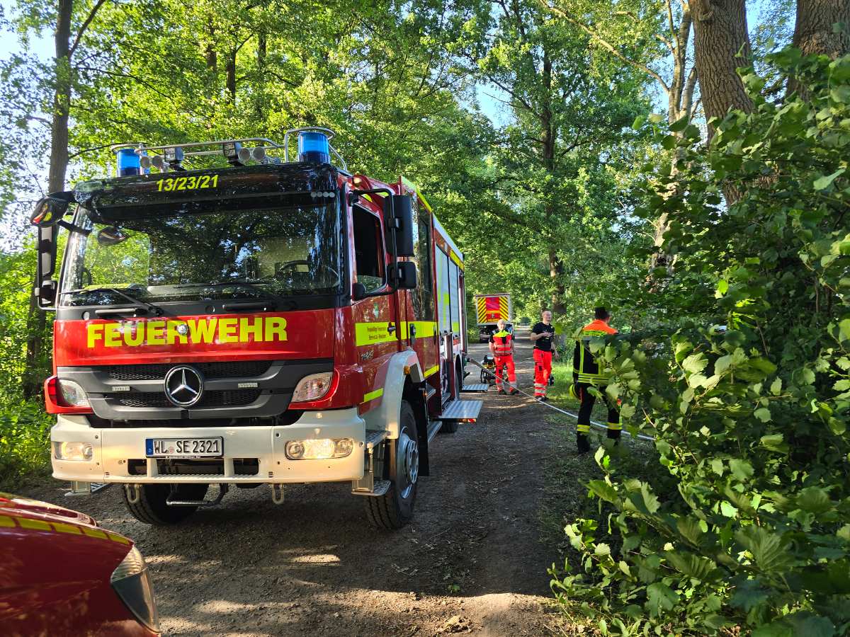 Erneuter Bombenfund in Helmstorf – Feuerwehren sichern Entschärfung 1 a fire truck parked on a dirt road with people in uniform