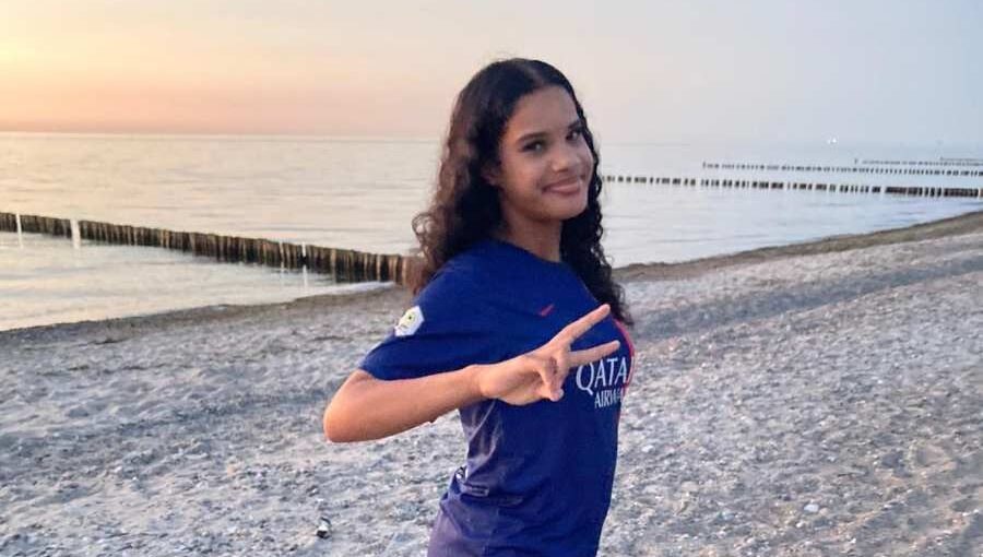 a woman standing on one leg on a beach