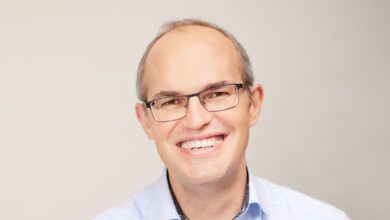 a man wearing glasses smiling