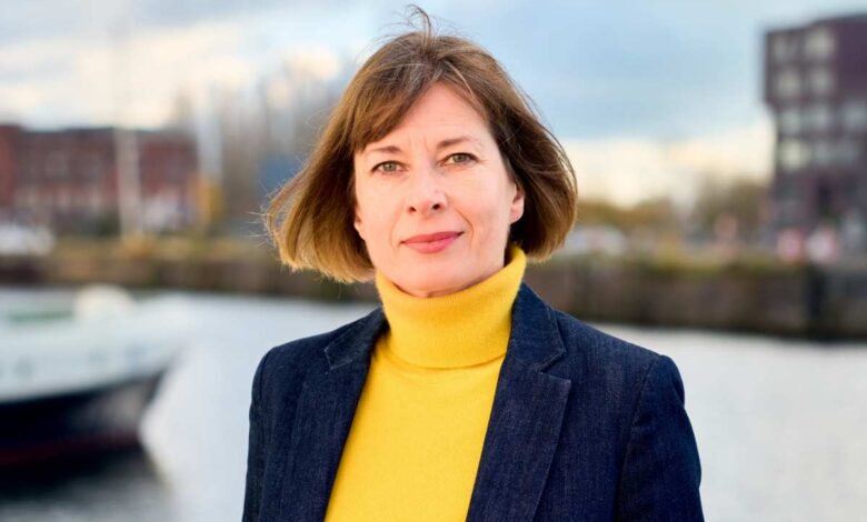 a woman in a yellow turtleneck and a blue blazer