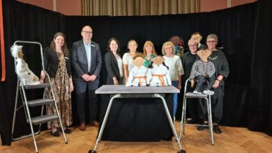 a group of people standing in front of a table with a group of people standing in front of them