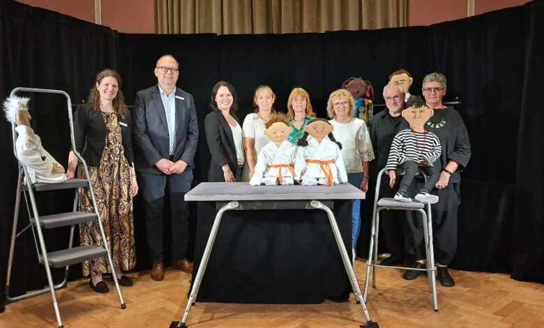 a group of people standing in front of a table with a group of people standing in front of them