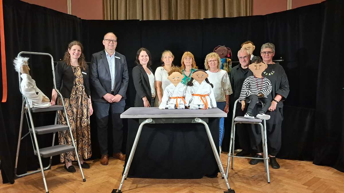 a group of people standing in front of a table with a group of people standing in front of them