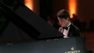 a man in a suit playing a piano