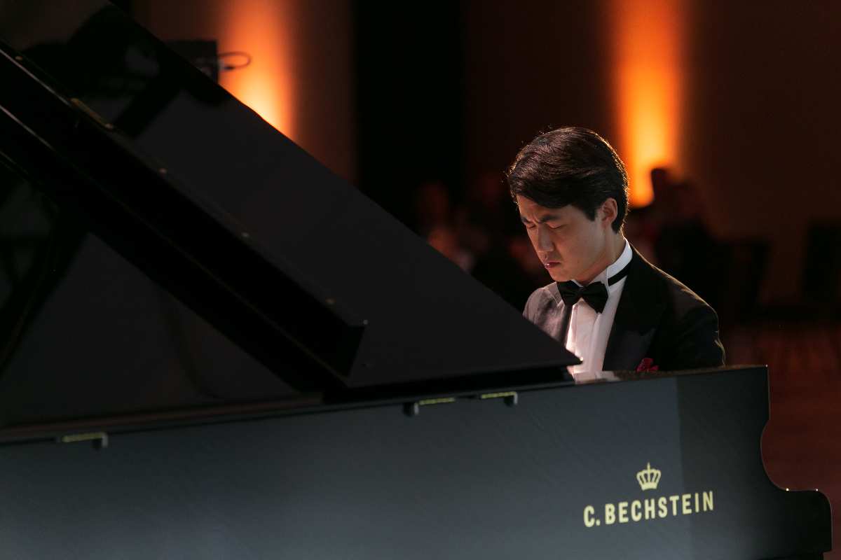 a man in a suit playing a piano