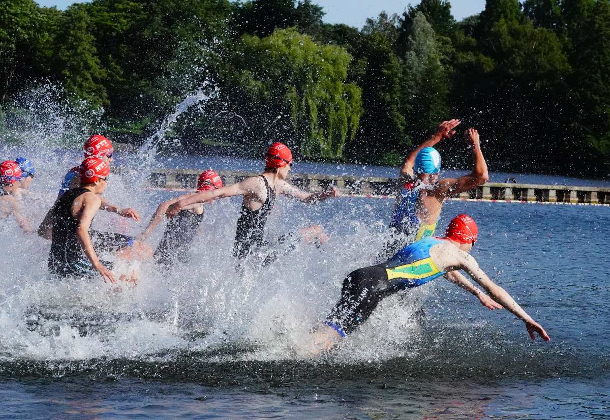 a group of people in swim caps swimming in water