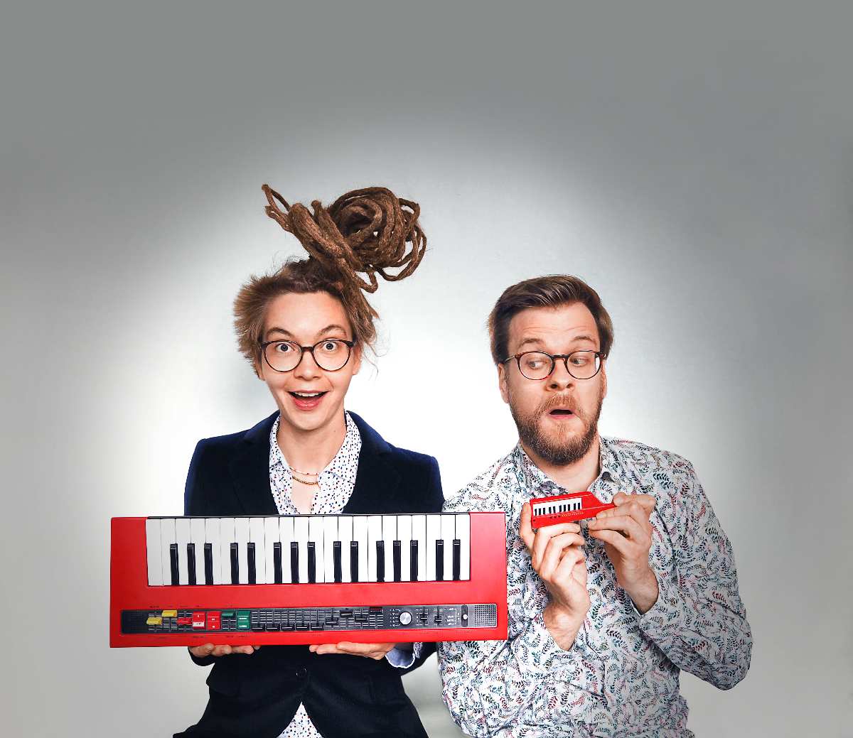 a man and woman holding a toy piano