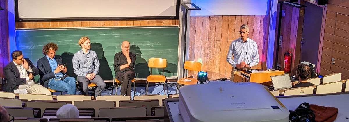 a group of people sitting in chairs in front of a green board