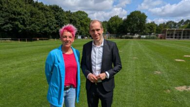 a man and woman standing in a field