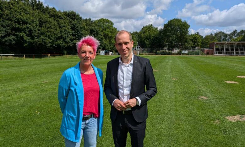 a man and woman standing in a field