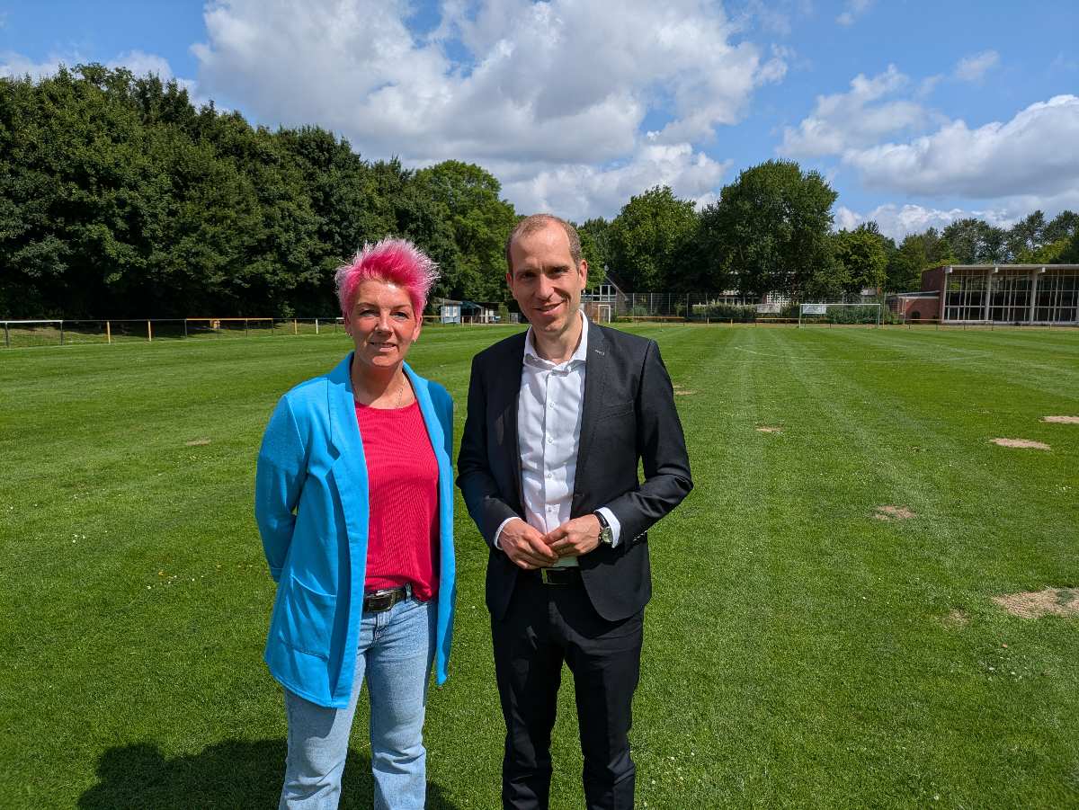 a man and woman standing in a field