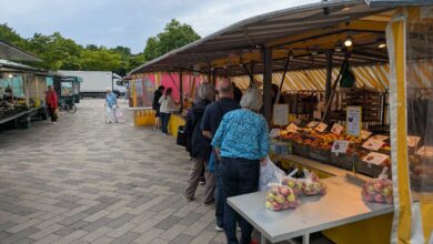 a group of people standing in a line at a market