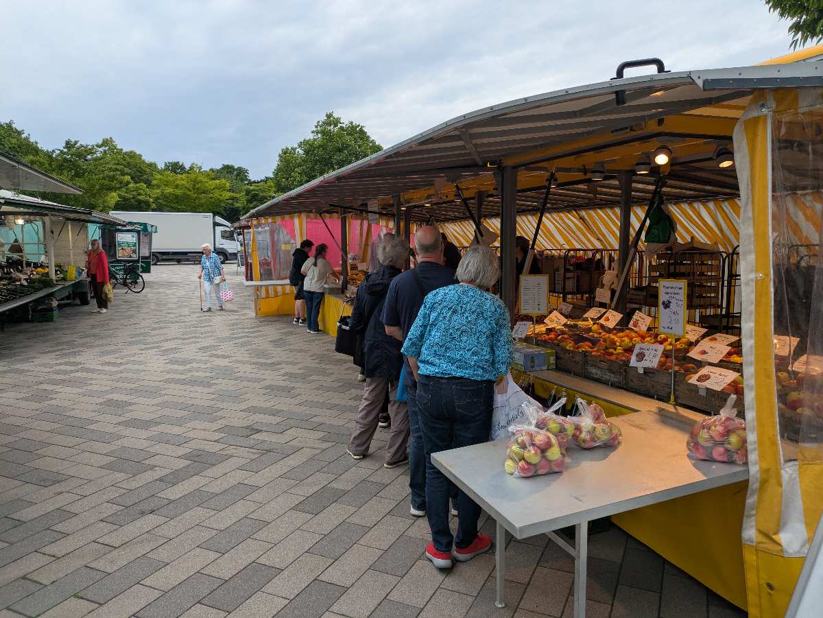 a group of people standing in a line at a market