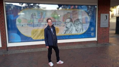 a man standing in front of a poster