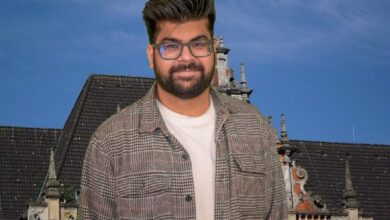 a man wearing glasses and a plaid jacket