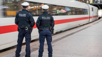 two police officers standing next to a train