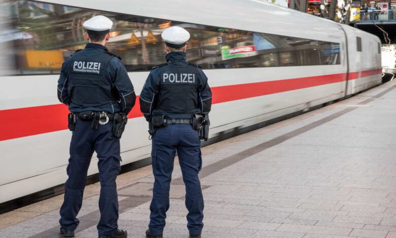 two police officers standing next to a train
