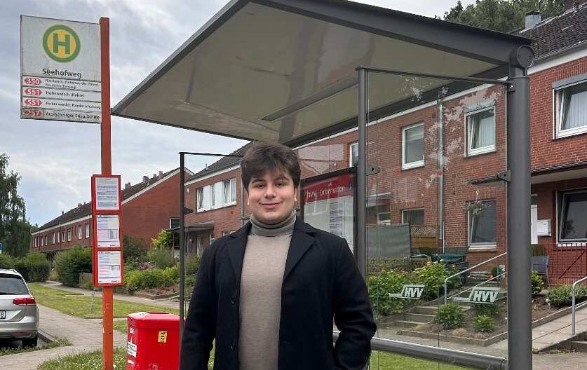 a man standing under a bus stop