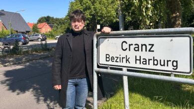 a man standing next to a sign
