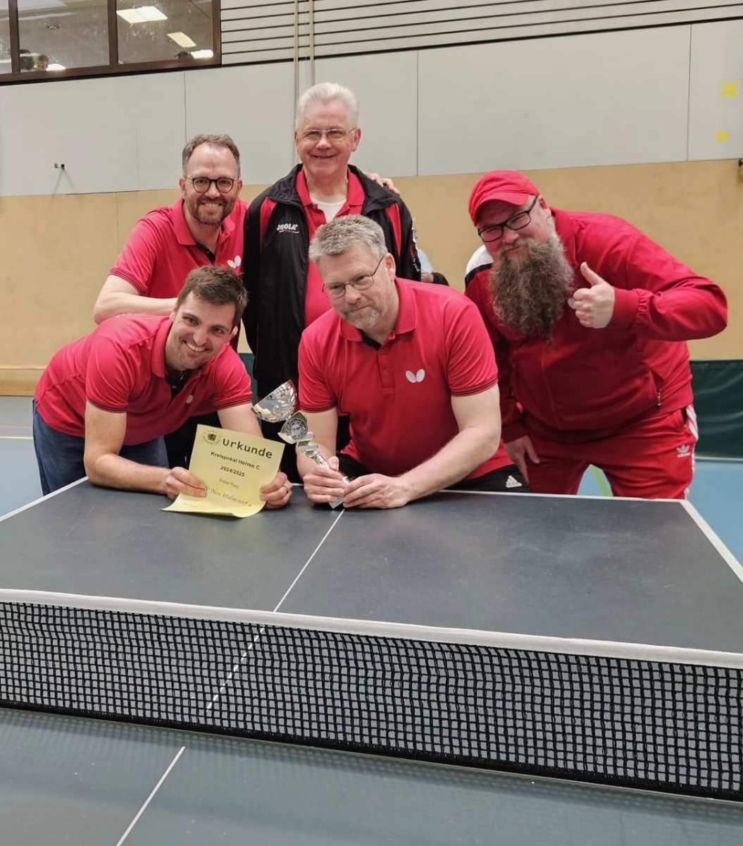 a group of men in red shirts posing for a photo