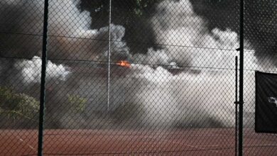 a fence with smoke and clouds of smoke behind it