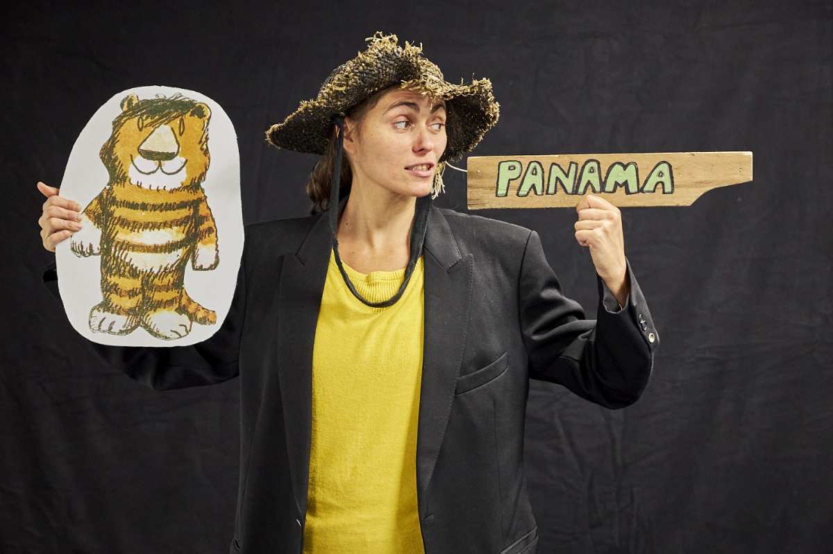 a woman holding a sign and a tiger