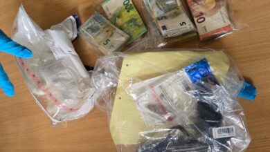 a bag of money and a gun on a table