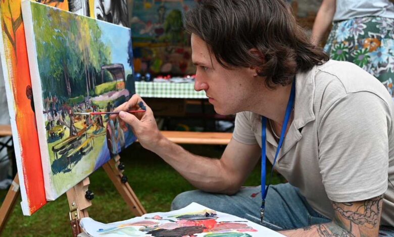 a man painting on a canvas