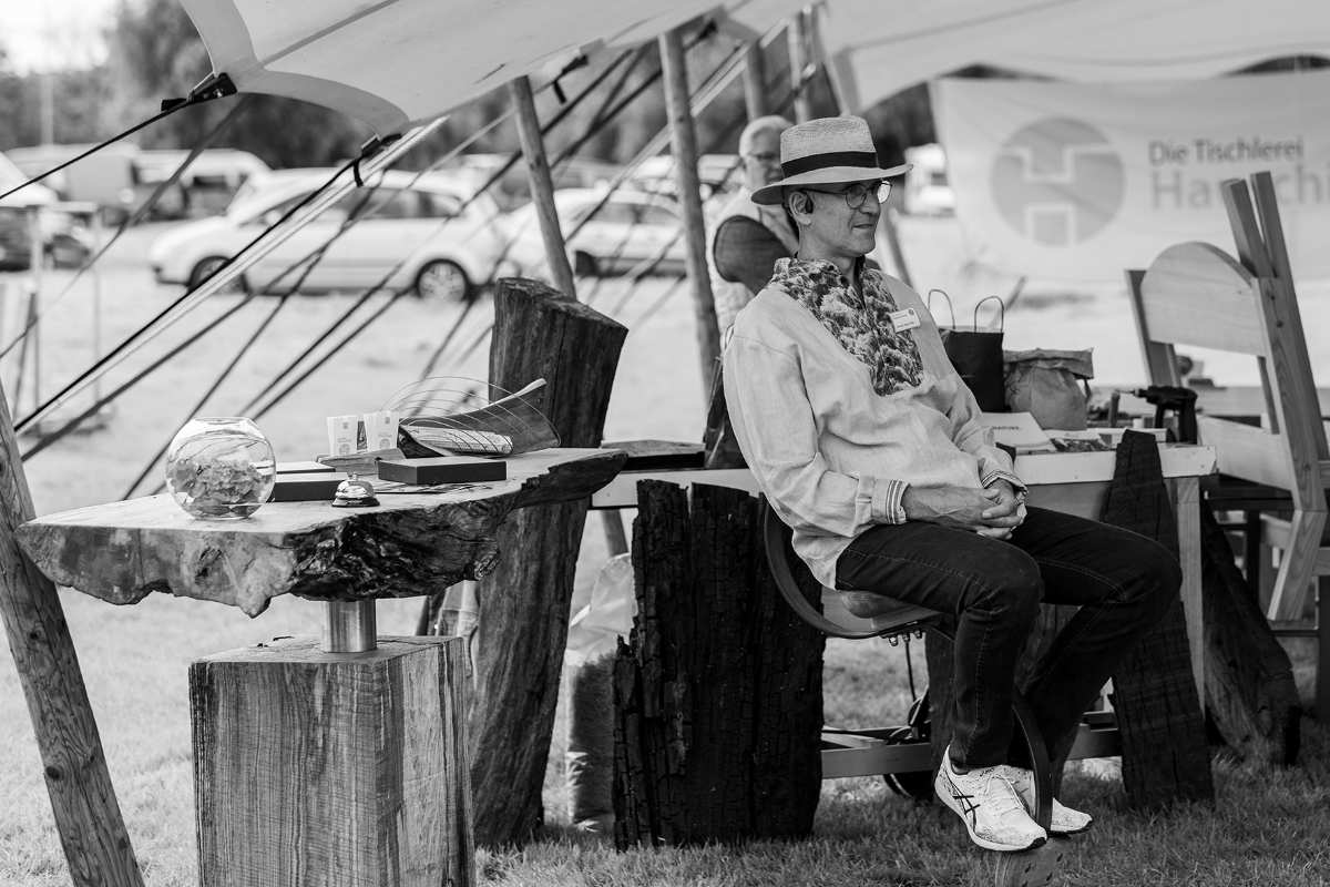 a man sitting on a bench under a tent